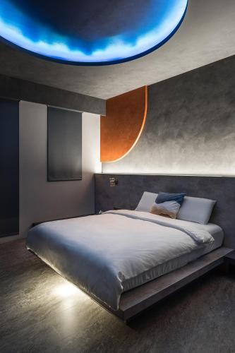 a bedroom with a large bed with a blue ceiling at ShanHeShu Homestay in Hualien City