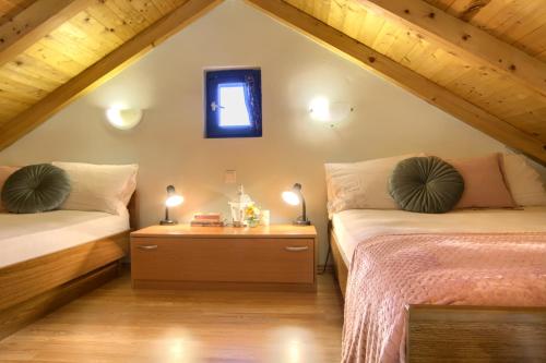 ein Schlafzimmer im Dachgeschoss mit zwei Betten und einem Fenster in der Unterkunft Holiday home Mola in Ugljan