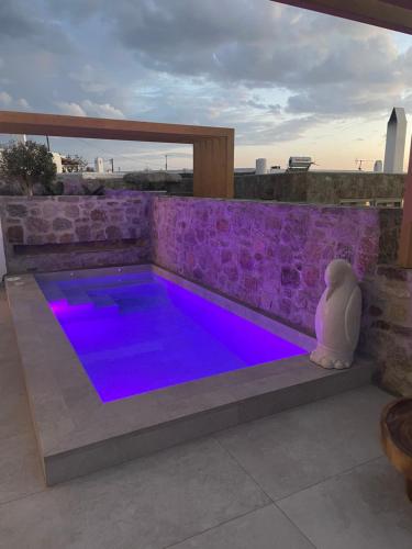 a swimming pool with purple lighting on a patio at Brilliance of Mykonos in Glastros