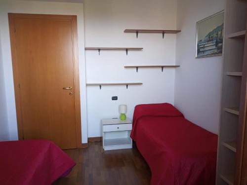 1 dormitorio con cama roja, puerta y estanterías en B&B Dosso Quarel, en Costermano