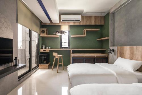 a bedroom with two beds and a green wall at ShanHeShu Homestay in Hualien City