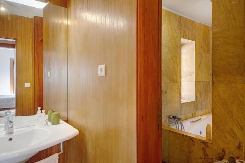 La salle de bains est pourvue d'un lavabo et d'une baignoire. dans l'établissement Villa do Bosque, à Guilhabreu