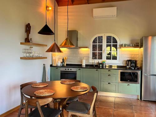 eine Küche mit Tisch und Stühlen und einem Kühlschrank in der Unterkunft Blooming Botanic Houses in Estreito da Calheta