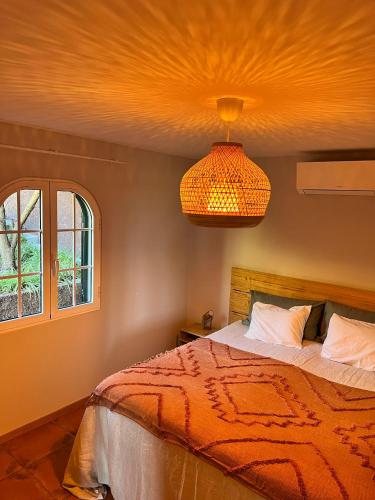 a bedroom with a bed and a chandelier at Blooming Botanic Houses in Estreito da Calheta