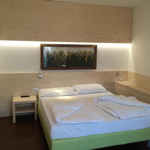 a bedroom with a bed with a painting on the wall at Komodo short stay apartments in Trento