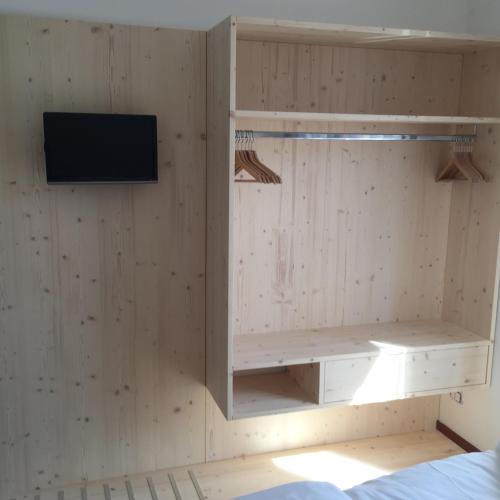 a room with a wall with a tv and a shelf at Komodo short stay apartments in Trento