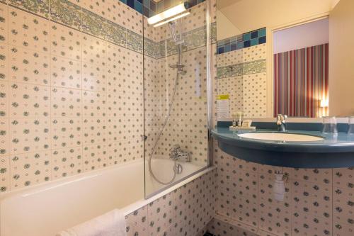 a bathroom with a sink and a shower at Hotel Clément in Paris