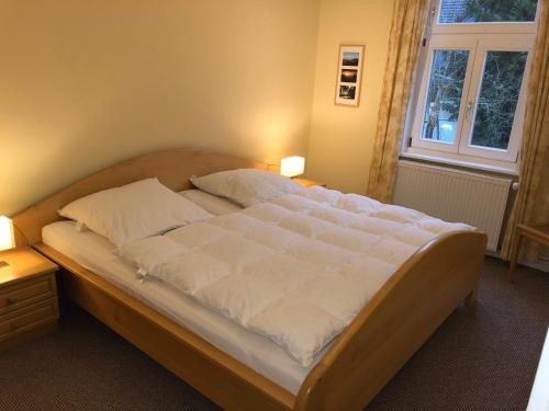 a large bed in a bedroom with two lamps at Landhaus Lautenthal in Lautenthal