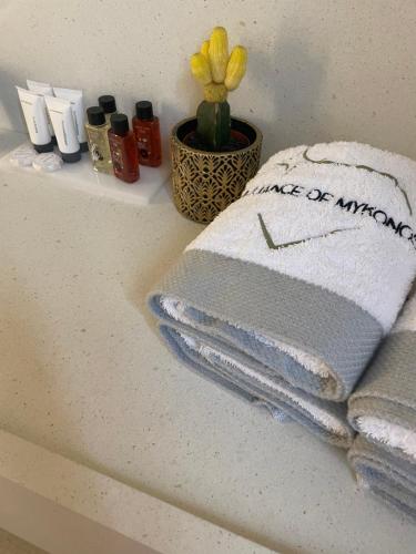 a bathroom counter with towels and a clock on it at Brilliance of Mykonos in Glastros