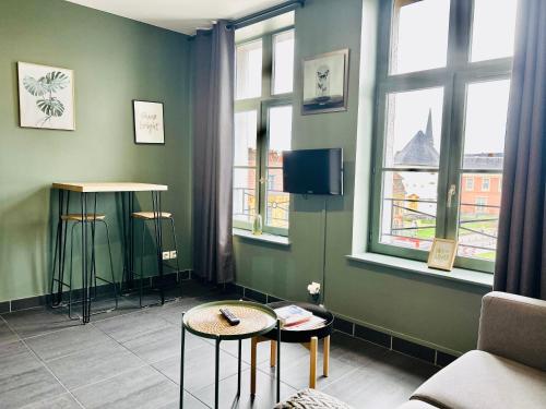 ein Wohnzimmer mit 2 Tischen und 2 Fenstern in der Unterkunft Vieux-Lille - Studio haut de gamme in Lille