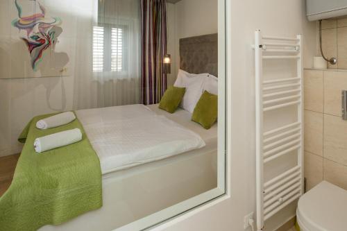 a bedroom with a mirror and a bed and a toilet at Pansion Kamenar in Primošten