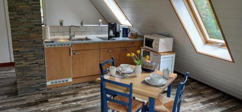 a kitchen with a table with chairs and a microwave at Gästehaus Zur alten Post in Dornumersiel