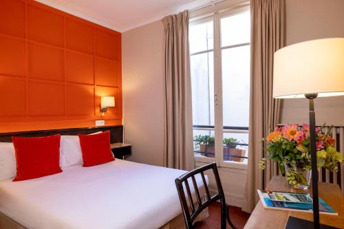 a hotel room with a bed and a window at Hotel Clément in Paris