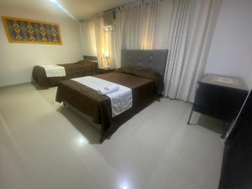 ブカラマンガにあるHotel Colonial Plazaのベッド2台とテレビが備わるホテルルームです。