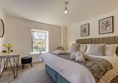 una camera con un grande letto e una scrivania di Helebridge House a Marhamchurch
