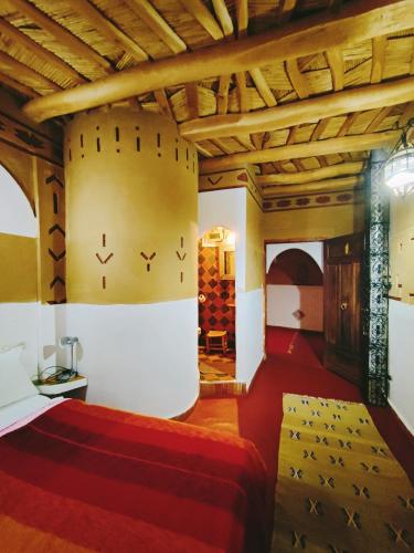 a bedroom with a bed and a wall with wine bottles at Auberge La Fibule Du Dades in Aït Idaïr