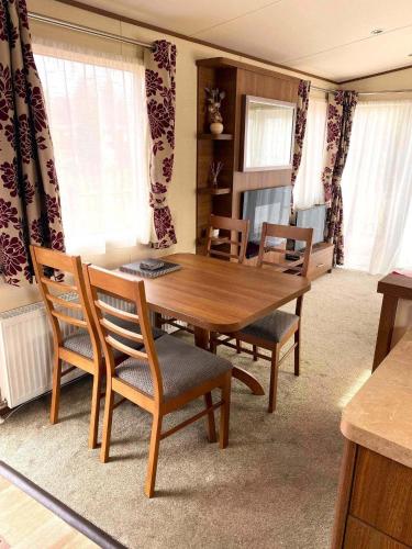 a dining room with a wooden table and chairs at Cabin 38 in Aviemore