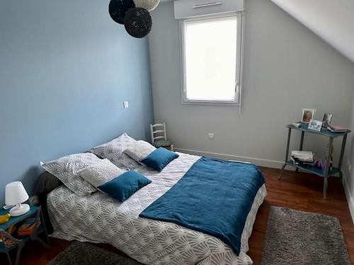 une chambre avec un lit aux murs bleus et une fenêtre dans l'établissement Maison proche circuit des 24h, au Mans