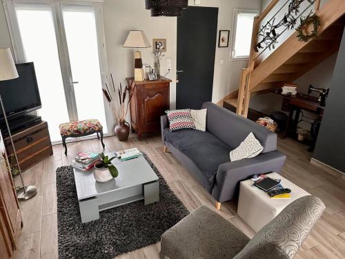 un salon avec un canapé et une table dans l'établissement Maison proche circuit des 24h, au Mans