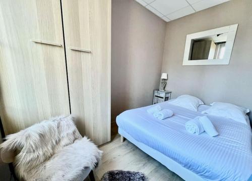 une chambre avec un lit blanc et une chaise dans l'établissement Appartement 2 pièces - PLACE MORNY, à Deauville