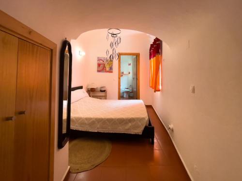 Habitación pequeña con cama y pasillo en Acolhedor espaço no centro da cidade, en Évora