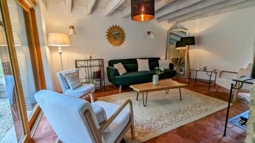 een woonkamer met een groene bank en een tafel bij Au fil du temps in Santenay