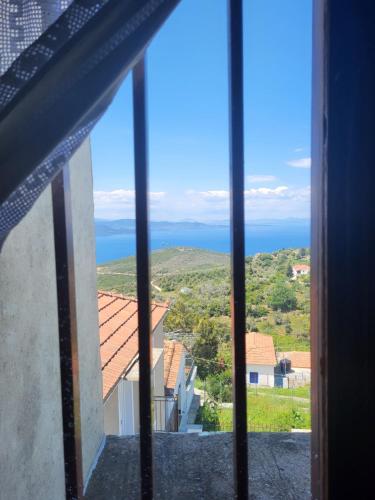 a view of the ocean from a window at Παραδοσιακό σπίτι με θέα in Tríkeri
