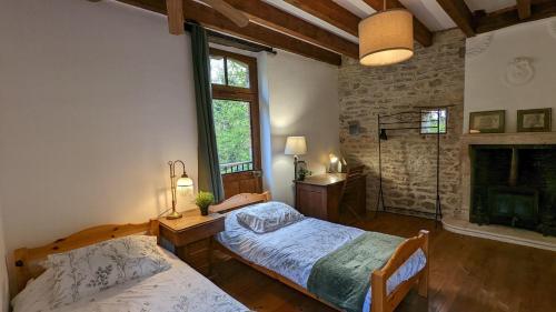 een slaapkamer met 2 bedden en een open haard bij Au fil du temps in Santenay