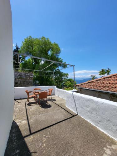 a patio with two tables and chairs on a roof at Παραδοσιακό σπίτι με θέα in Tríkeri