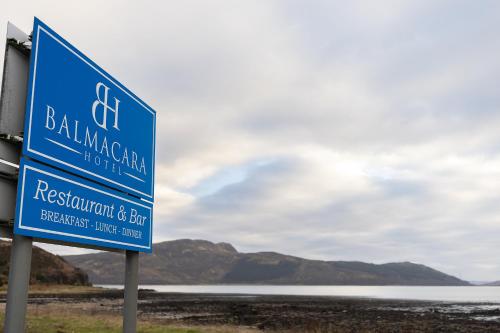 a blue sign in front of a body of water at Balmacara Hotel in Kyle of Lochalsh