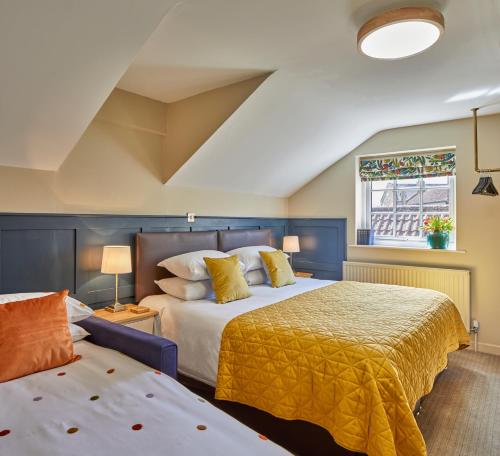 a bedroom with two beds and a window at Full Moon Inn Rudge in Frome