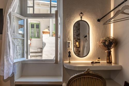 a bathroom with a mirror and a sink and a window at The Locals in Káto Potamiá