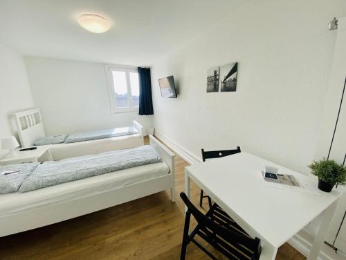 a room with two beds and a table and a desk at Monteurzimmer - Worker's accommodation - ZIMMERzuVERMIETEN in Lengnau BE in Lengnau