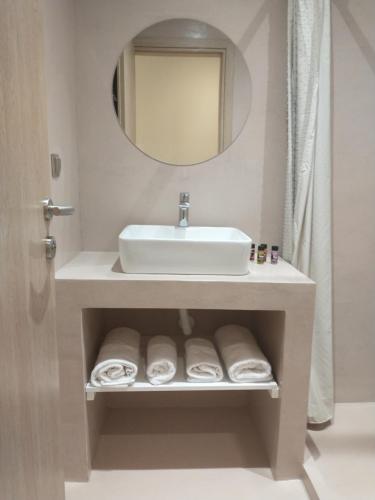 La salle de bains est pourvue d'un lavabo, d'un miroir et de serviettes. dans l'établissement Menta, à Litochoro