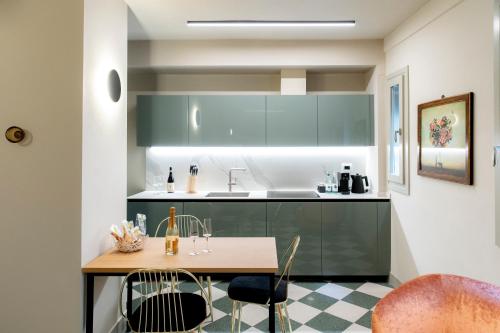 a kitchen with green cabinets and a wooden table at Palazzo Scappi Gardi Luxury Apartments in Bologna