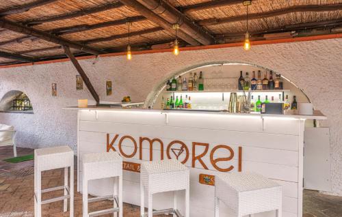 a bar with white stools and a counter with a bar at Hotel San Valentino Terme in Ischia