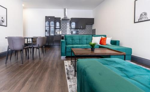 a living room with a green couch and a table at Water Street by Ustay Aparthotels in Liverpool