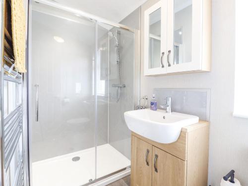 a bathroom with a shower and a sink and a mirror at 36 Bucklesham Park in Ipswich