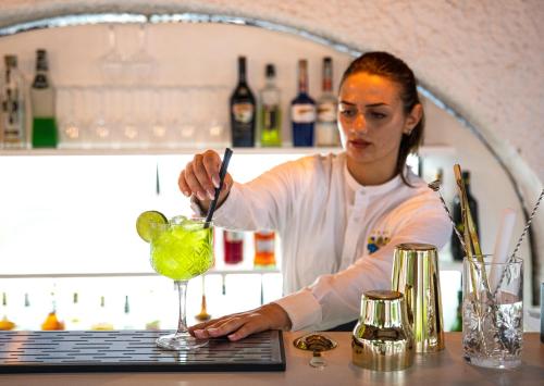 a woman preparing a drink in front of a keyboard at Hotel San Valentino Terme in Ischia