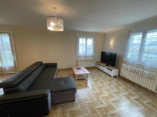a living room with a couch and a flat screen tv at Green Gables- Old Charm in Vézeronce