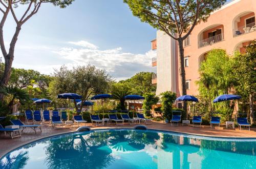 a pool at a hotel with chairs and umbrellas at Hotel San Valentino Terme in Ischia