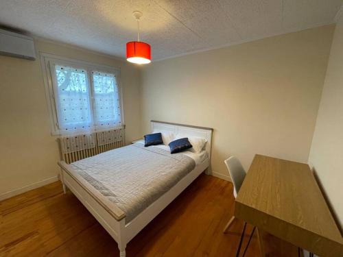 a bedroom with a bed and a table and a window at Green Gables- Old Charm in Vézeronce