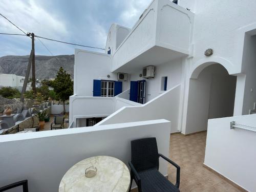 a balcony with white walls and a table and chairs at Leonidas Apartments in Kamari