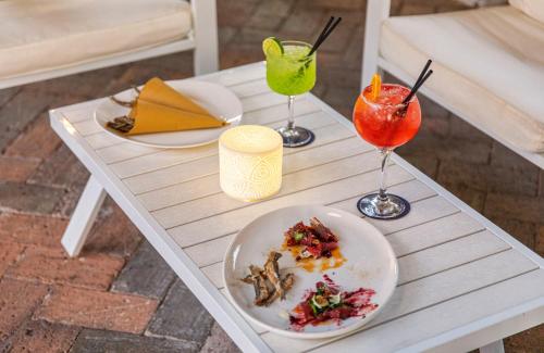 a table with two drinks and a plate of food at Hotel San Valentino Terme in Ischia