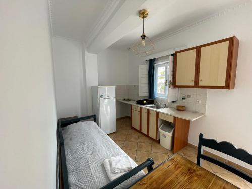 uma pequena cozinha com uma mesa e um frigorífico em Leonidas Apartments em Kamari