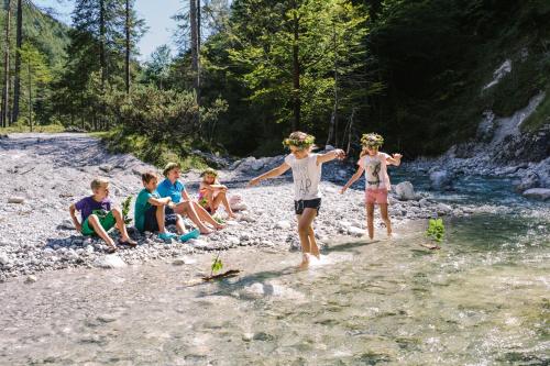 a group of children playing in the water on a river at Ferienwohnung Litzlhof in Itter