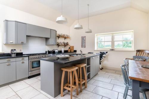 a kitchen with gray cabinets and a table and chairs at The Cowshed in Laurencekirk