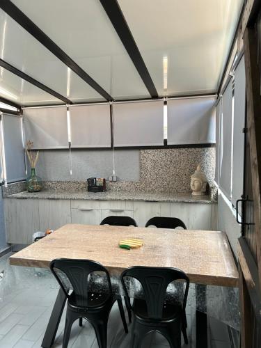 uma cozinha com mesa e cadeiras num quarto em la maison des sables 4 port leucate em Port Leucate