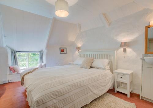 Helford的住宿－Mimosa，白色的卧室设有床和窗户