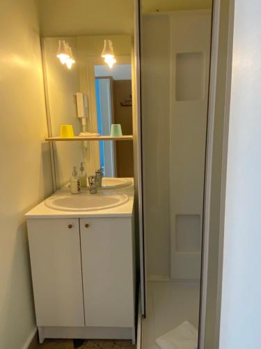La salle de bains est pourvue d'un lavabo et d'un miroir. dans l'établissement Oscar Hôtel Le Havre Centre, au Havre